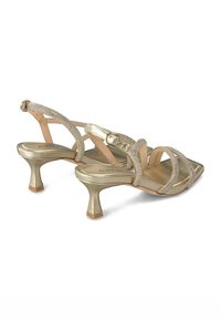 Sandales à talons dorés avec une tige métallique, des lanières étincelantes, un bout carré et un talon bloc de hauteur intermédiaire pour un meilleur maintien.