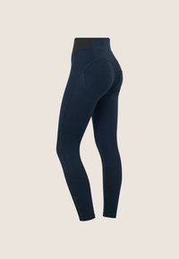 Leggings a vita alta blu navy con dettagli a cucitura curva e un pannello elastico nero sulla vita posteriore su uno sfondo neutro.