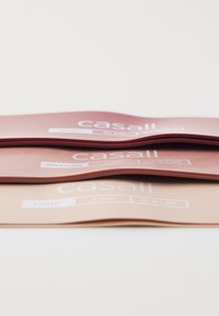 Three exercise resistance bands stacked: red (hard), pink (medium), beige (light). Rubber material with white labels displaying weight ratings.