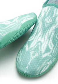 Minzgrüne Slipper aus strukturiertem Stoff mit einem wellenförmigen Muster und einer Gummisohle für guten Halt. Smoothe, nahtlose Gestaltung.