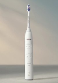 Philips Sonicare elektrische tandenborstel, witte kunststof handgreep, blauwe en paarse borstelkop, ronde knoppen, LED-indicatorlampjes, ergonomisch ontwerp.