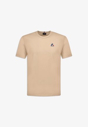 T-shirt in cotone beige con scollo rotondo e maniche corte. Presenta un piccolo logo ricamato sul lato sinistro del petto. Texture morbida e liscia.