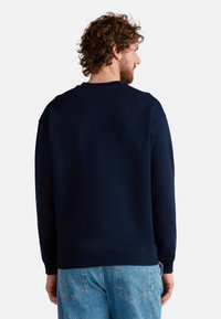 Marineblauwe sweatshirt met lange mouwen, geribbelde ronde halslijn en een gestructureerde stof. Beschikt over een ontspannen pasvorm en een eenvoudige achterkant.