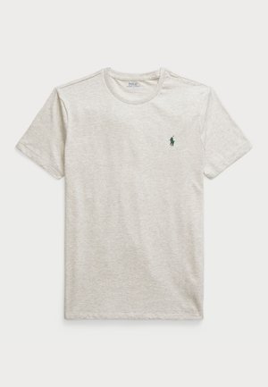 Svetlo siva bombažna majica z okroglim izrezom, kratkimi rokavi in majhnim zelenim logotipom na levi strani prsnega koša. Gladka tekstura, sproščen kroj.