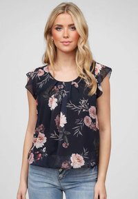 Blouse navy avec des motifs floraux roses et verts, dotée d'un col rond, de plis à l'avant et de manches courtes à volants.