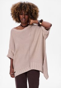 Beige gebreide trui met een loose fit, een brede halslijn, korte mouwen en ribgebreide accenten. Heeft een gestructureerd patroon aan één kant.