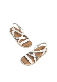 White leather sandals with silver cross-strap accents, a brown cushioned footbed, and a textured espadrille sole.