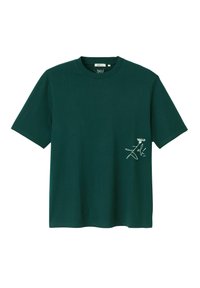 T-shirt vert foncé à manches courtes et col rond avec un petit motif blanc et du texte sur la partie gauche de la poitrine.