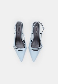 Vaaleansiniset nahkaiset slingback-kengät, joissa on teräväkärkiset varpaat, kaksoishihnat ja hopeiset yksityiskohdat. Sileä pinta ja tyylikäs muotoilu.