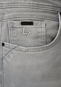 Szare dżinsy z denimu z tylną kieszenią ozdobioną haftowanym logo "L" oraz małą czarną metką marki, prezentujące gładką teksturę i schludny design.