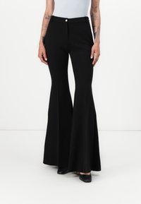 Pantaloni negri evazați cu talie înaltă, confecționați dintr-un material elastic. Prezintă un top ajustat și picioare late, accentuate de un nasture frontal.