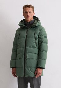 Zielona puchowa kurtka z zamkiem błyskawicznym, dwoma przednimi kieszeniami i odpinanym kapturem. Posiada teksturowaną warstwę wewnętrzną i gładką powierzchnię zewnętrzną.