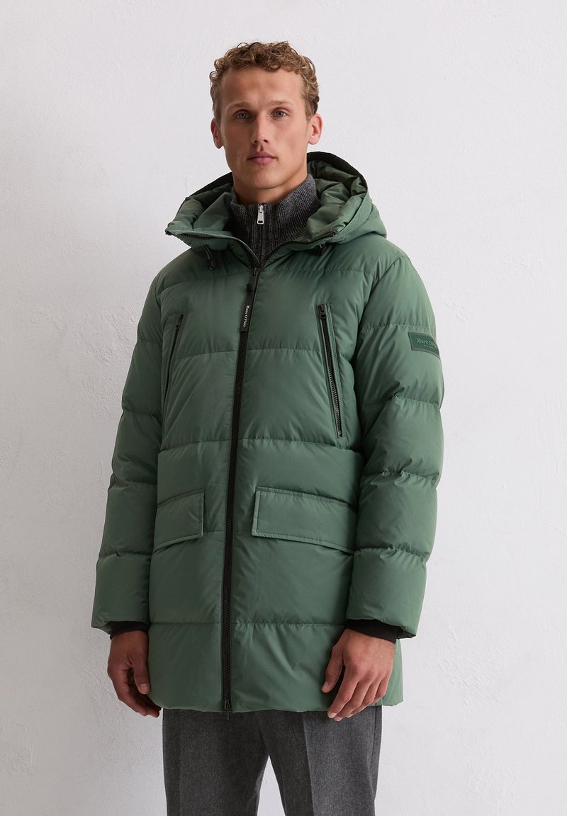 Zielona puchowa kurtka z zamkiem błyskawicznym, dwoma przednimi kieszeniami i odpinanym kapturem. Posiada teksturowaną warstwę wewnętrzną i gładką powierzchnię zewnętrzną.