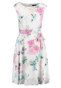 Blommig klänning med lätt tyg, rund halsringning, axelärmar och midjeband, prydd med rosa och gröna blommönster på en vit bakgrund.