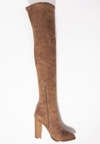 Bota de ante marrón sobre la rodilla con un tacón texturizado y estriado y un cierre lateral. Presenta un diseño elegante y ajustado con punta redondeada.