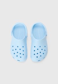 Light blue plastic clogs with vent holes and back straps, featuring a textured insole for grip and comfort. Smooth finish overall.