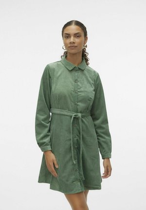Robe-chemise en velours côtelé vert avec un col, des manches longues, un bouton devant et une ceinture assortie à la taille. Texture douce et ourlet évasé.
