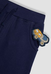 Navy cotton sweatpants with a patch featuring a multi-colored truck. Features elastic waistband and side pockets for comfort.