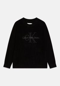 Maglione nero a costine con collo rotondo, caratterizzato da un logo grigio "Calvin Klein Jeans" al centro. Maniche lunghe e tessuto testurizzato.