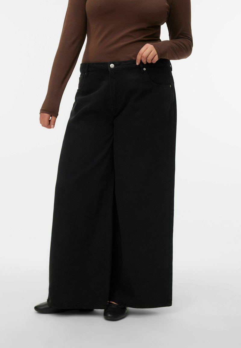 Zwarte wijde jeans van denim, met een hoge taille, knoop- en ritssluiting, en twee voorzakken. De stof heeft een gladde textuur.