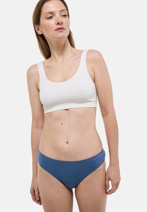 Bralette blanc côtelé associé à un slip bikini bleu texturé, avec des bords lisses et une coupe modeste. Design simple sans ornements.