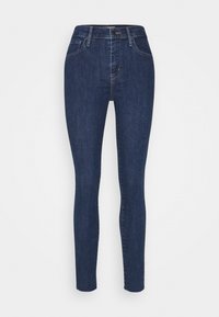 Vaqueros ajustados de mezclilla azul oscura. Diseño de cintura alta con cinco bolsillos y sutilezas en los detalles de costura. Textura suave y forma ceñida.