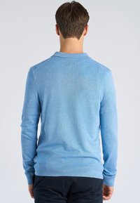 Jasnoniebieski sweter, dzianinowy materiał, długie rękawy, kołnierz, dopasowany krój, prążkowane ściągacze, gładka tekstura, widok od tyłu, brak widocznych logo lub wzorów.