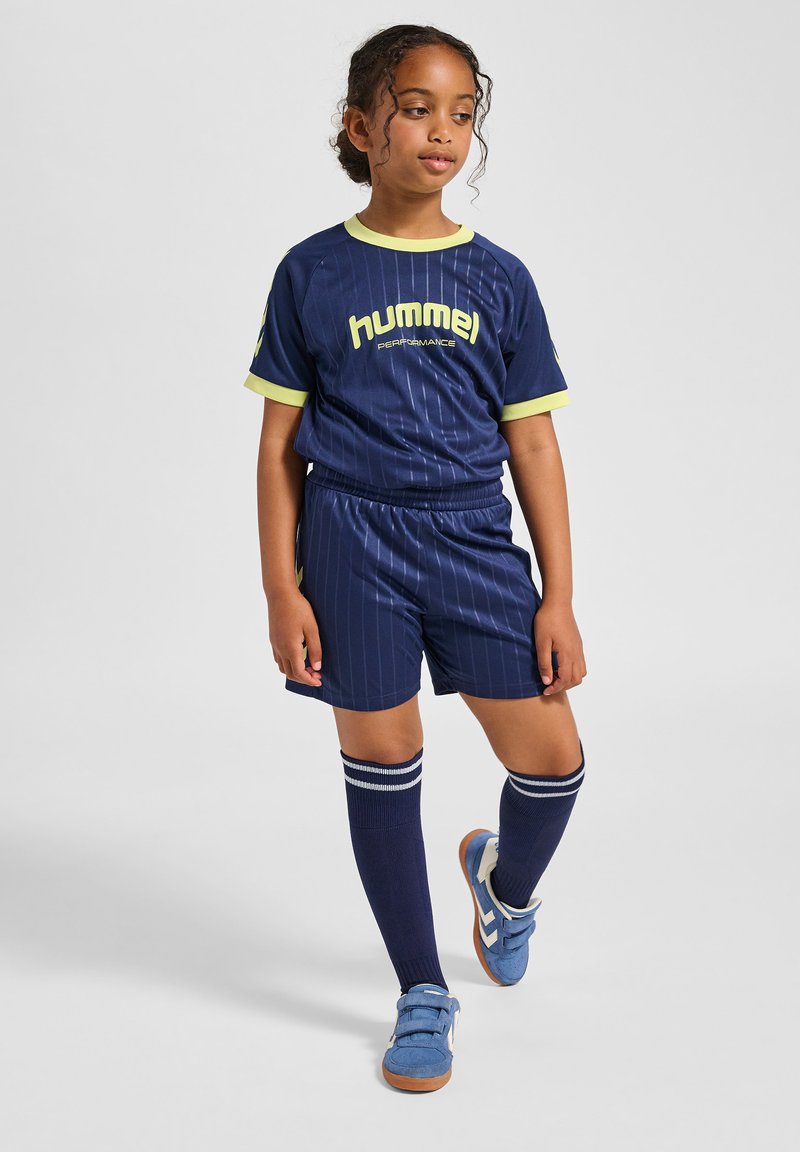 Marynarski strój piłkarski z żółtymi akcentami, z wzorem w prążki. Zawiera koszulkę z krótkim rękawem, szorty i skarpety do kolan.