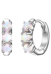 Hopeapronssit, joissa on kolme pyöreää opaaliakiveä, kukin varmistettu kynsisarjaan, kiiltävällä pinnalla ja sileällä tekstuurilla.