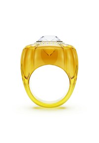 Anillo amarillo de gran tamaño con un diamante transparente en la parte superior y pequeños acentos, presentado sobre un fondo blanco, destacando su diseño audaz.