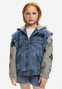 Džínová bunda se šedou kapucí. Má přední kapsy, zapínání na knoflíky a dekorativní potisky na rukávech. Modro-šedá barevná kombinace.