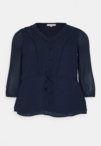 Marineblaue, semi-transparente Bluse mit Dreiviertelärmeln, Knopfleiste und Bindegürtel. Strukturiertes Muster und dezente Rüschendetails entlang des Ausschnitts.