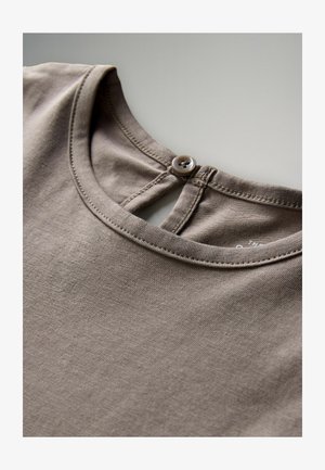 Nahaufnahme des taupefarbenen Baumwollhemdkragens mit rundem Kragen und kleiner Knopfverschluss hinten.