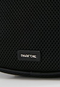 Zwarte netten tas heeft een gestructureerd oppervlak, ronde vorm en een rechthoekig zwart label met de zilveren merknaam "PARFOIS."