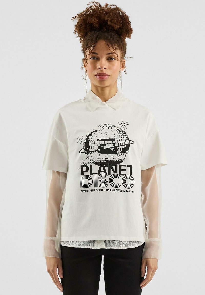 Weißes T-Shirt mit kurzen Ärmeln, das ein schwarzes Druckmotiv einer Discokugel und den Text "PLANET DISCO" in fetter Schrift zeigt. Mit transparenten Akzenten an den Ärmeln.