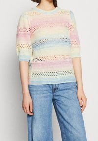 Sweter z dzianiny w pastelowe paski w kolorach różowym, niebieskim, żółtym i białym, z wzorami ażurowymi, krótkimi bufiastymi rękawami i okrągłym dekoltem.