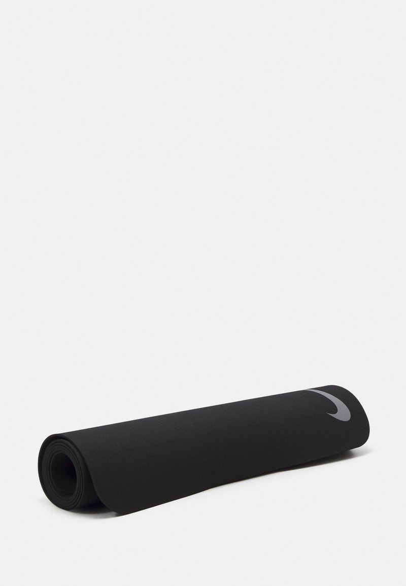 Svart yogamatte, rullet sammen, laget av strukturert materiale. Har en grå Nike-logo på den ene siden. Runde ender, jevn overflate.