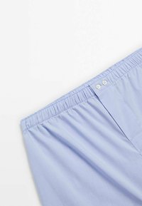 Světle modré kraťasy s elastickým pasem, které mají dva bílé knoflíkové detaily a hladkou, lehkou texturu látky.