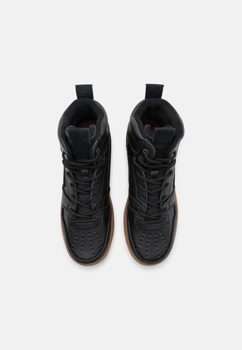 Sneaker alte nere con un mix di pelle e tessuto, punta rotonda, design perforato sulla punta e suola in gomma.