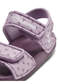 Fioletowe sandały z regulowanymi paskami na rzepy, ozdobione teksturowanym wzorem małych logo oraz wyposażone w profilowaną wkładkę dla komfortu.