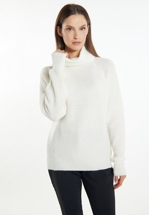 Pulover alb din tricot cu guler înalt, textură corduroy și mâneci lungi. Are o croială lejeră și o margine din spate ușor mai lungă.