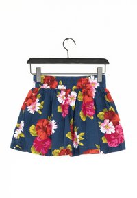 Blommig kjol med en marinblå bakgrund, prydd med stora röda och vita blommor. Elastisk midja, veckad design och tillverkad av bomull.