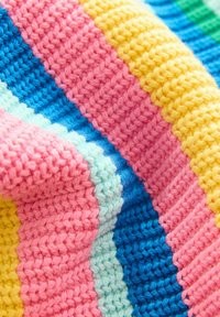 Knitted blanket featuring alternating stripes of pink, blue, yellow, and mint green. Textured yarn creates a soft, cozy appearance.