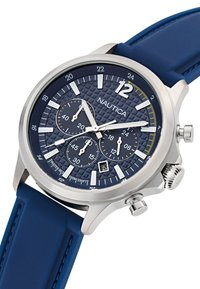 L'orologio Nautica presenta una cassa in acciaio inossidabile, un cinturino in gomma blu, un quadrante navy testurizzato con lancette luminose e tre sottodial.
