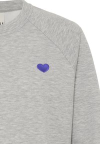Szara bluza z miękką fakturą, z małym niebieskim haftowanym sercem na piersi i rękawami raglanowymi.