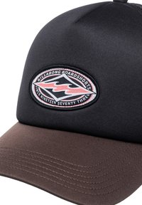 Svart og brun caps med buet skjerm. Har et sirkulært brodert logo i rødt og svart med teksten "Billabong Boardshorts".