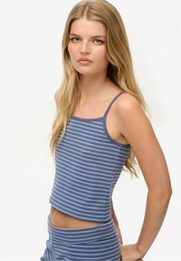 Top de tirantes fino a rayas azul y gris con un diseño corto. Textura de tela suave, forma ajustada.