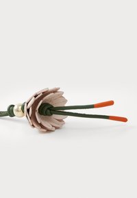 Leather flower accessory with pink petal-like layers, green base, and two elongated green stems with orange tips. Gold bead accent.