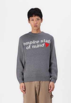 Grå stickad tröja med texten 'empire state of mind' i vitt och ett rött hjärta som accent. Rundad halsringning och ribbade ärmslut och nederkant.