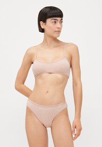 Light brown ribbed bikini set featuring a bralette and matching briefs. The fabric is soft with thin adjustable straps and a subtle logo detail.
